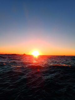 綺麗な夕陽と波立つ海