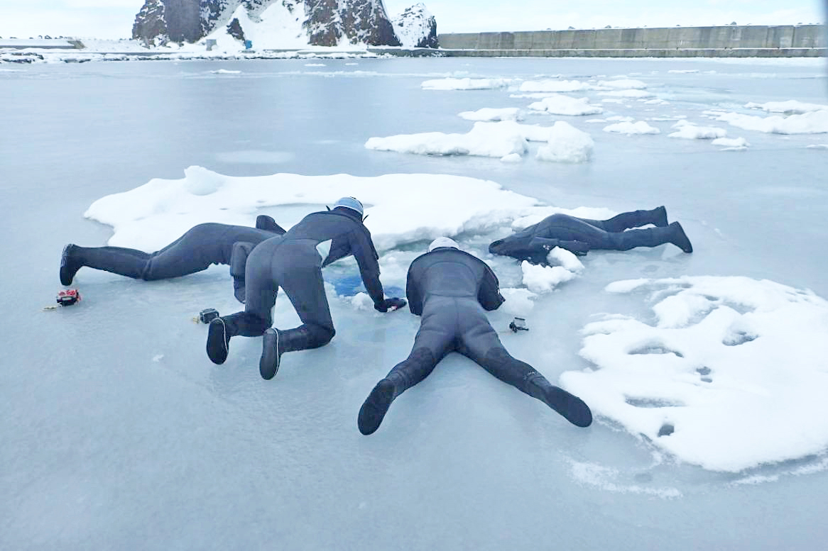 －2℃の流氷直下の海をのぞき込む